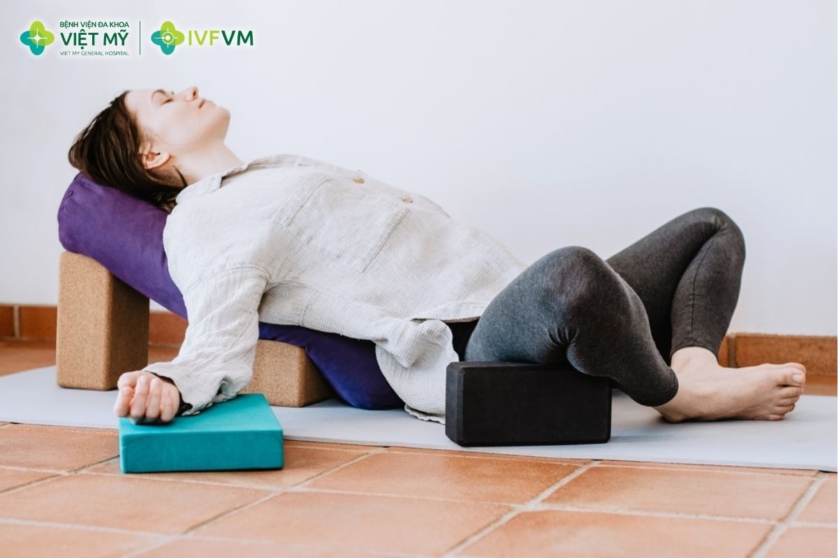 Tư thế con bướm nằm ngửa có gối đỡ hỗ trợ thư giãn vùng hông và háng sau thủ thuật